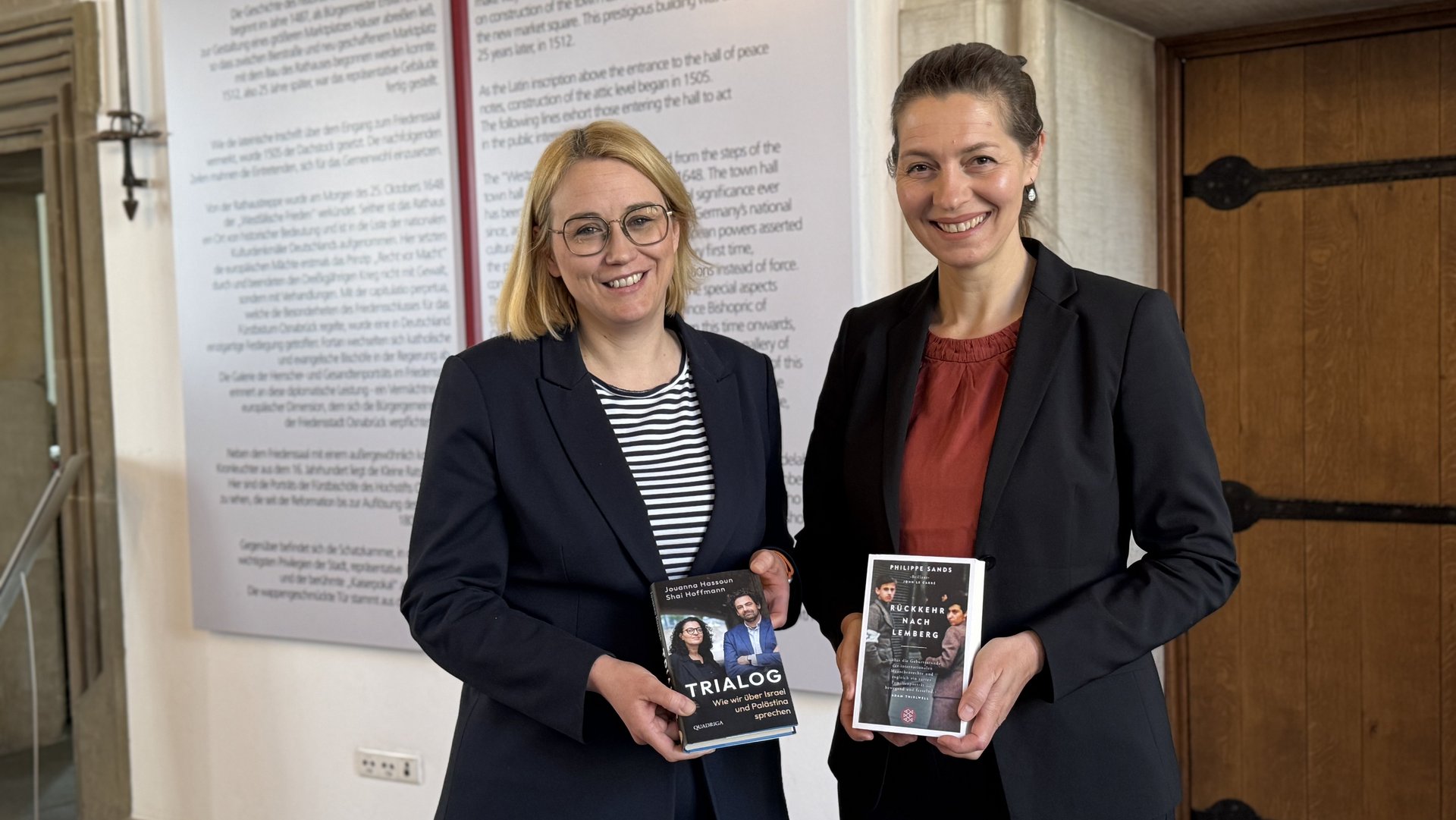Zwei Frauen. Beide halten ein Buch in der Hand.