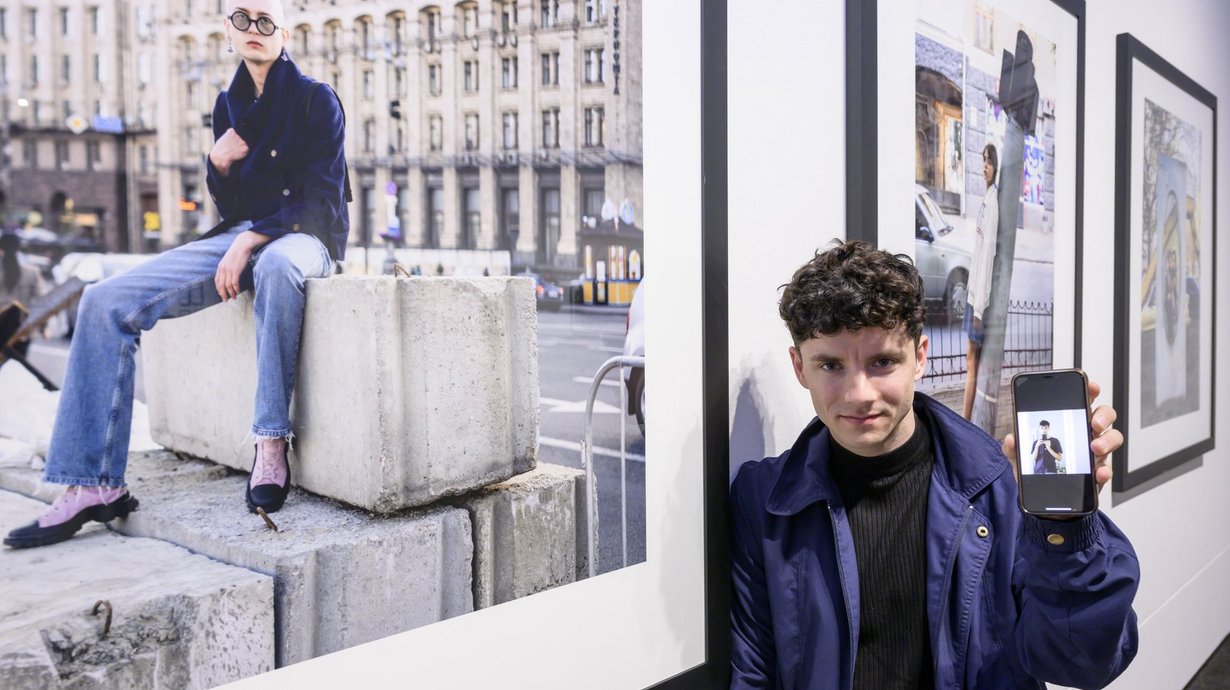 Sebastian Wells und Vsevolod Kazarin (auf dem Smartphone), Preisträger des Deutschen Friedenspreis für Fotografie 2023), vor ihrer Arbeit „Young People Photographed in Kyiv, April and May 2022“ 