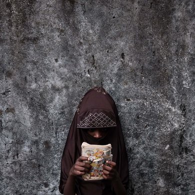 Fatimah ist 6 Jahre alt und wurde in der Gefangenschaft von Boko Haram von einer Mutter geboren, die bei einem Überfall starb. Sie verbringt Zeit im Haus ihrer Großfamilie in Borno im Nordosten Nigerias und schaut Bilder eines Comics „Archie“ an, in der Hoffnung, dass sie eines Tages zur Schule gehen wird. Foto: Emeke Obanor
