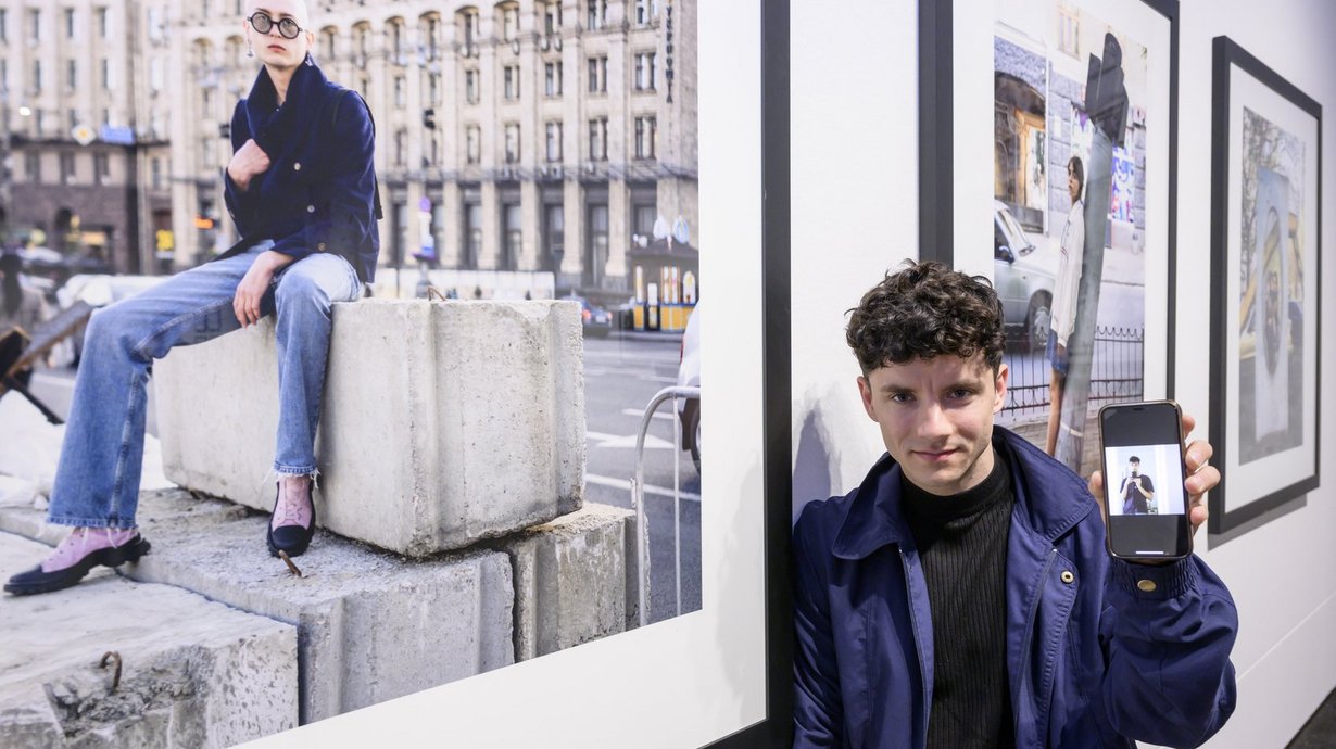 Sebastian Wells und Vsevolod Kazarin (auf dem Smartphone) vor dem Gewinnerbild „Young People Photographed in Kyiv, April and May 2022“.