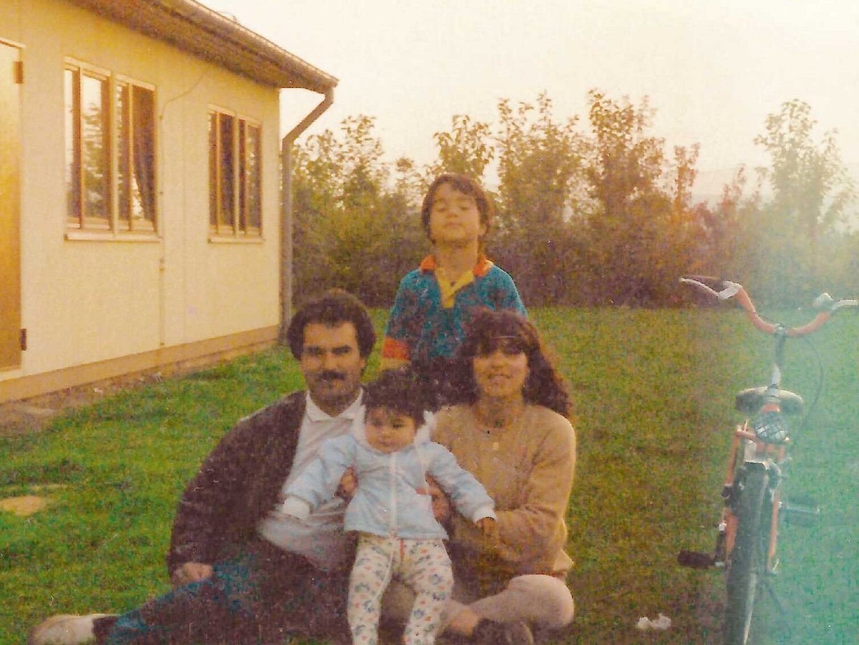 Ein Buchumschlag, der eine im Garten sitzenden Familie zeigt