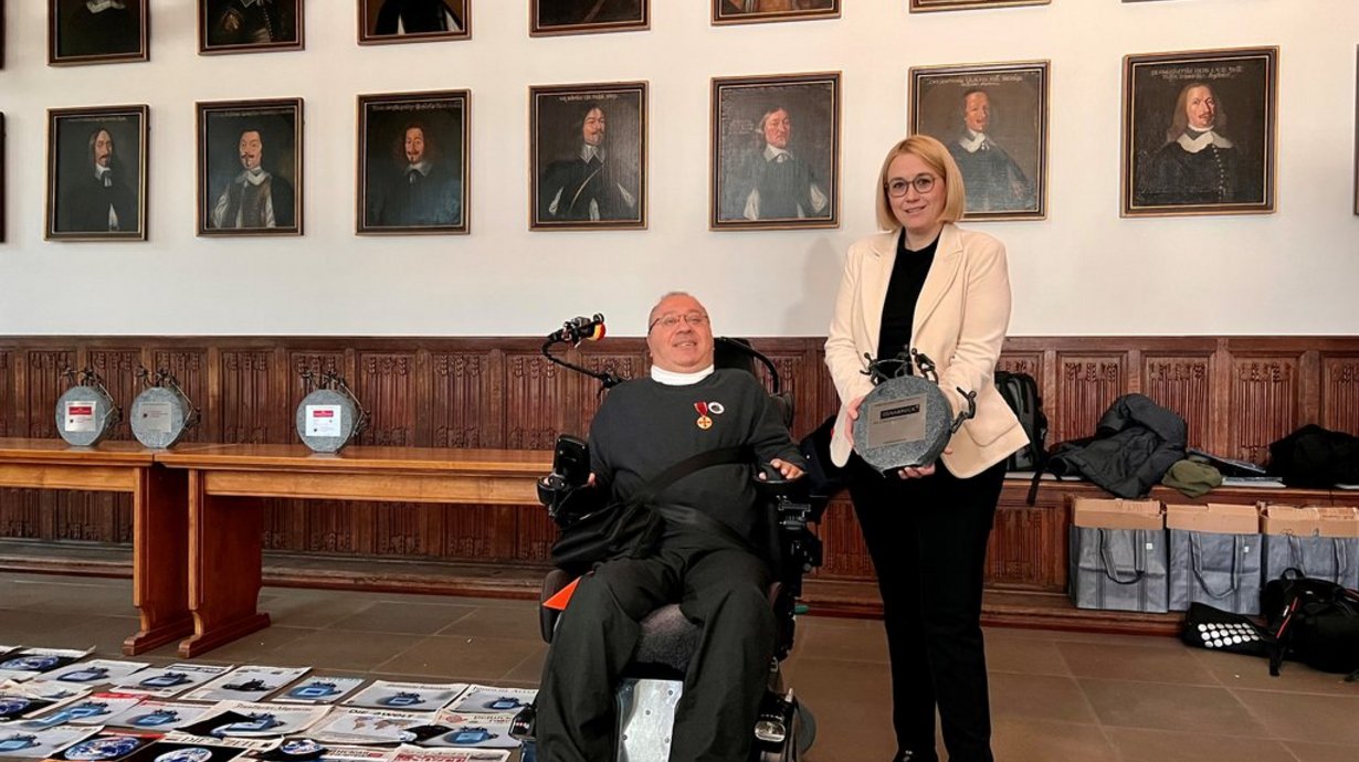 Dr. Faraj Remmo überrecht Oberbürgermeisterin Katharina Pötter im Friedenssaal die "Danke-Skulptur".
